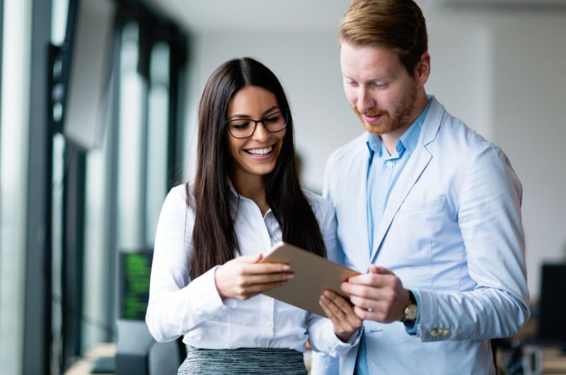 Twee professionals waren bezig met UI-testen terwijl ze een tablet in een kantooromgeving onderzochten.